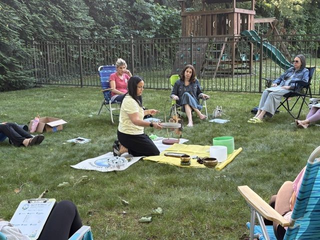 Mel leading the group with sound bowls on a blanket